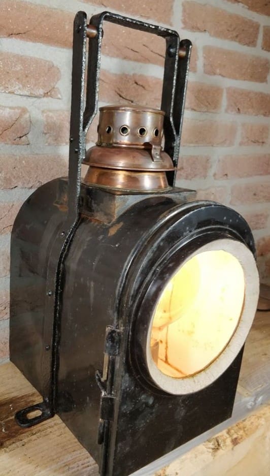 Brandende wagonlamp met koperen schoorsteen