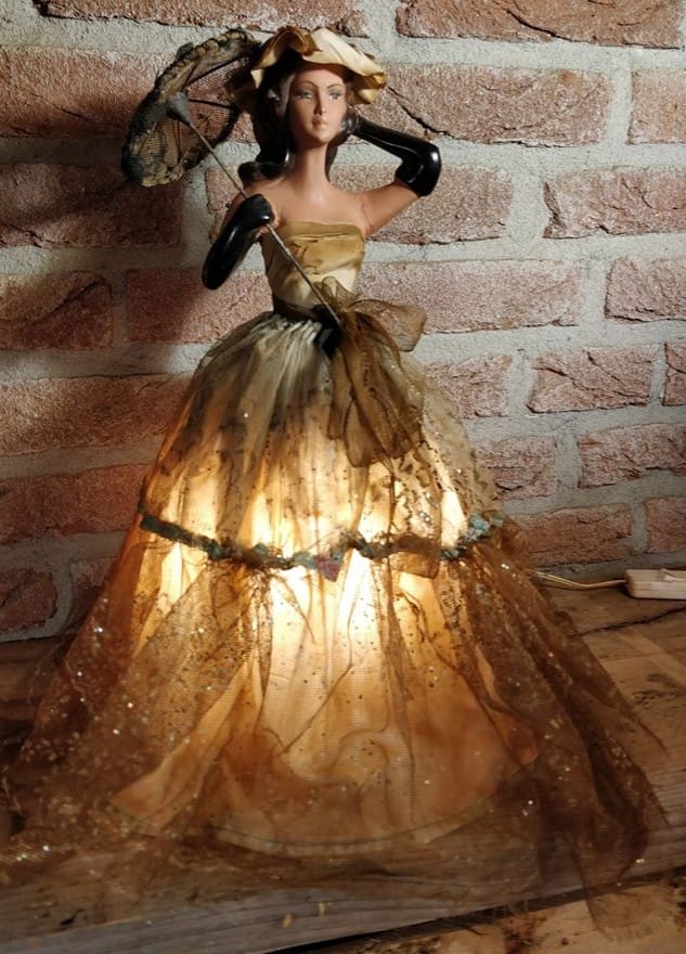 victoriaanse lamp van vrouw in jurk waarbij de lamp onder de jurk zit