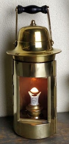 Prachtige kompaslamp van messing welke een porseleinen lonthouder heeft die u ziet branden.