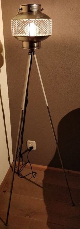 Staande lamp met een riverdale windlicht geplaatst op een oude camera statief