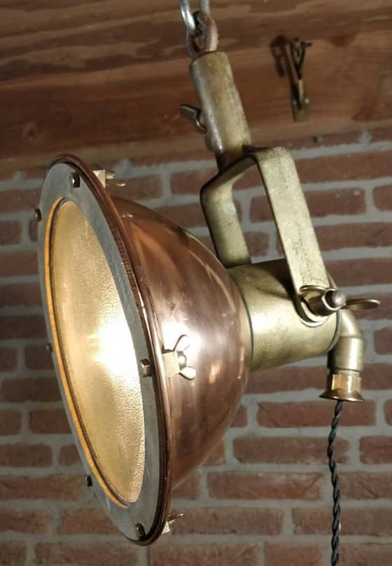 Klein model scheepsdeklamp van koper. Deze lamp staat ook bekend als zoeklicht
