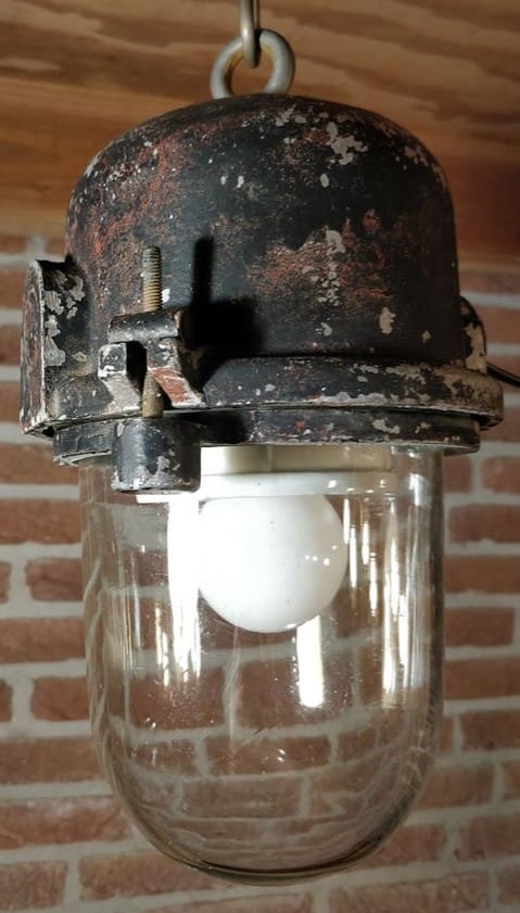 Bunkerlamp met dik glas hangend aan het plafon